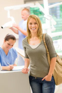 Smiling woman leaving office with receptionist behind her