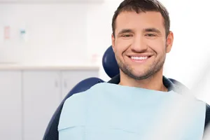 Happy male patient in dentist chair