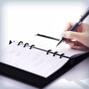 Person writing in personal appointment calendar